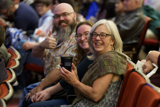 audience members smile and give a thumbs up before the concert