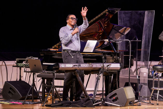 Herbie Hancock waves at the audience from behind the keyboard