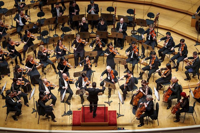 an overhead shot of James Gaffigan on the podium, along with the CSO strings and winds sections, mid-performance