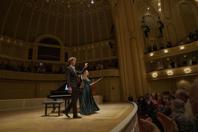 violinist Julia Fischer and pianist Jan Lisiecki holding hands and bowing together