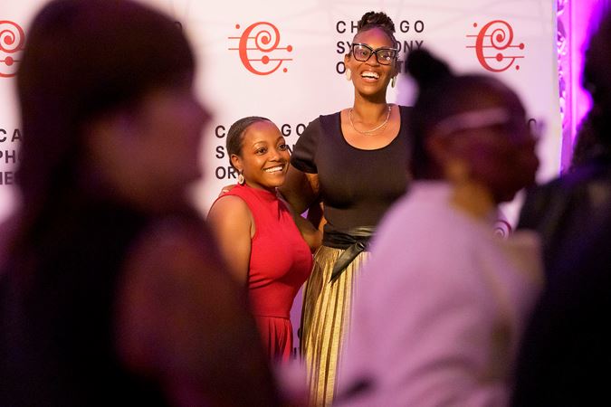 Underground attendees smiling in front of the step-and-repeat