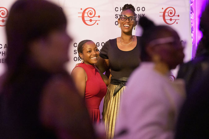 Underground attendees smiling in front of the step-and-repeat