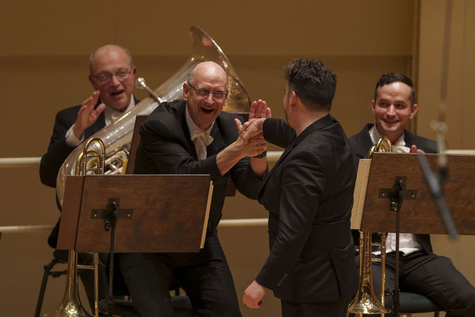 it's all smiles as James Gaffigan shakes the hand of CSO acting principal trombone Michael Mulcahy after the performance