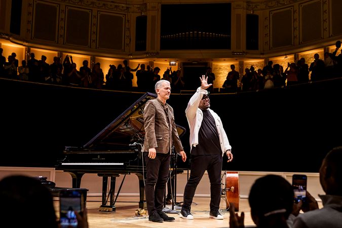 Christian McBride waves at the audience as he and Brad Mehldau take their final bows