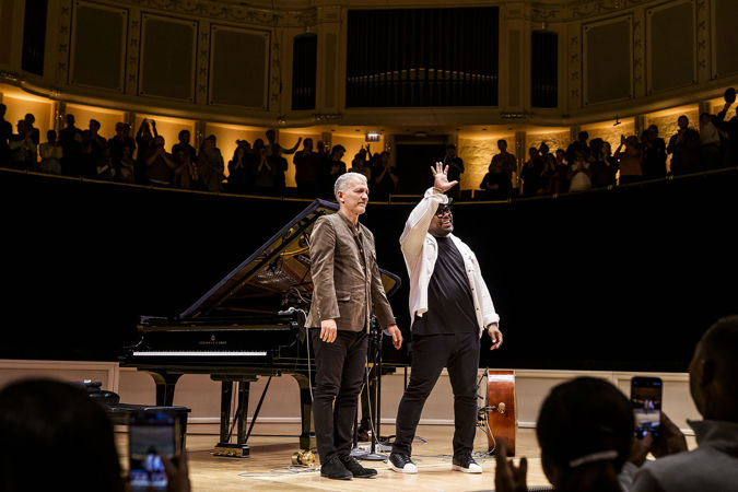 Christian McBride waves at the audience as he and Brad Mehldau take their final bows