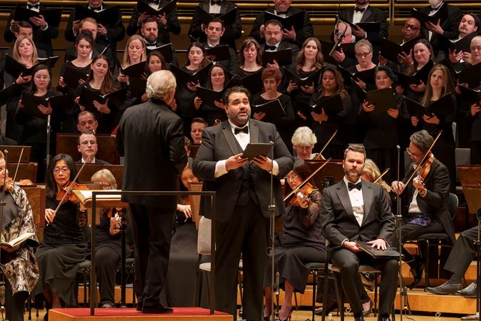 Close up of tenor Andrew Haji singing on stage