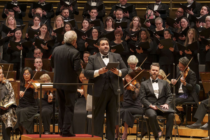 Close up of tenor Andrew Haji singing on stage