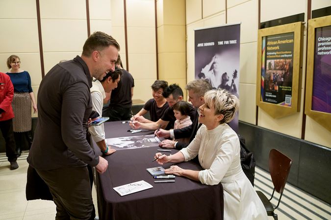 Joyce DiDonato greets a fan with an enthusiastic smile at a postconcert signing event