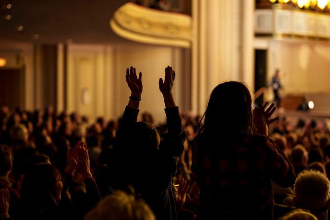 audience members give a standing ovation