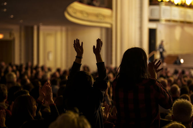 audience members give a standing ovation