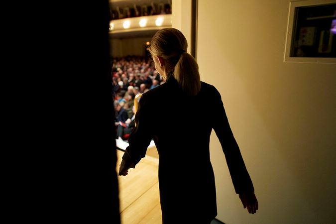 the camera follows Karina Canellakis as she walks through the backstage doors and out in front of a cheering crowd in Orchestra Hall