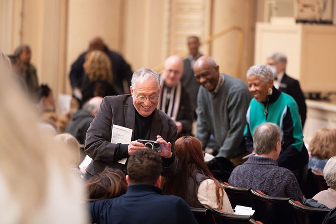 An audience member taking a photo of two other audience members in Orchestra Hall