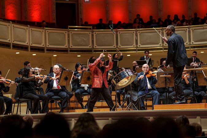 Action shot of Steelpan player and 2024 winner of the Crain-Maling Young Artists Competition Jaden Teague-Núñez performing with members of the CSO