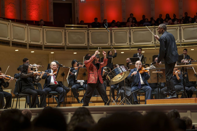 Action shot of Steelpan player and 2024 winner of the Crain-Maling Young Artists Competition Jaden Teague-Núñez performing with members of the CSO