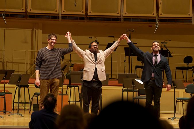 composers Adam Schoenberg, Quinn Mason and Jimmy López raise their hands in a post-performance bow