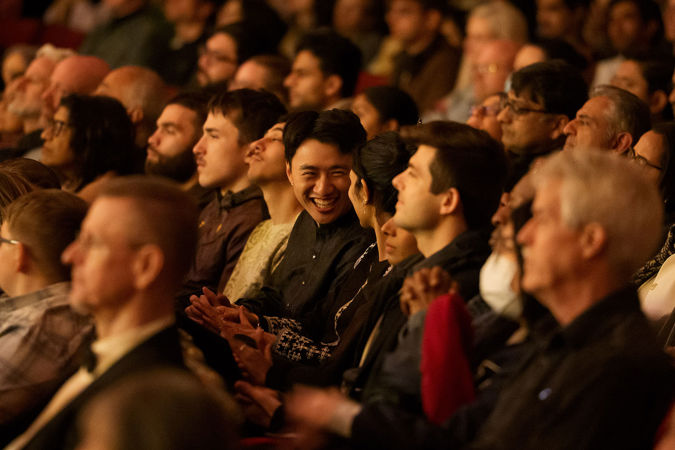 the audience smiles and claps along during the performance