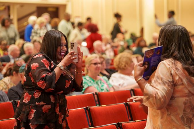 A patron takes a photo of another patron in Orchestra Hall
