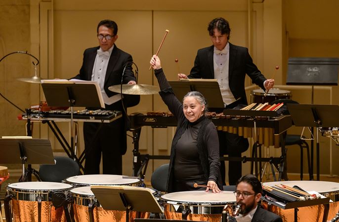 Sinfónica de Minería timpanist Gabriela Jiménez raises her mallet in triumph