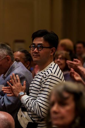 Closeup action shot of a patron applauding from the Main Floor at the end of Víkingur Ólafsson's piano recital