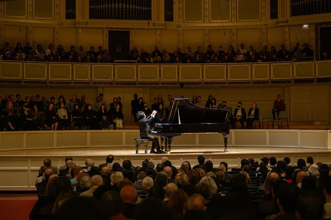 South Korean pianist Yunchan Lim raises his hands above his instrument in a final flourish