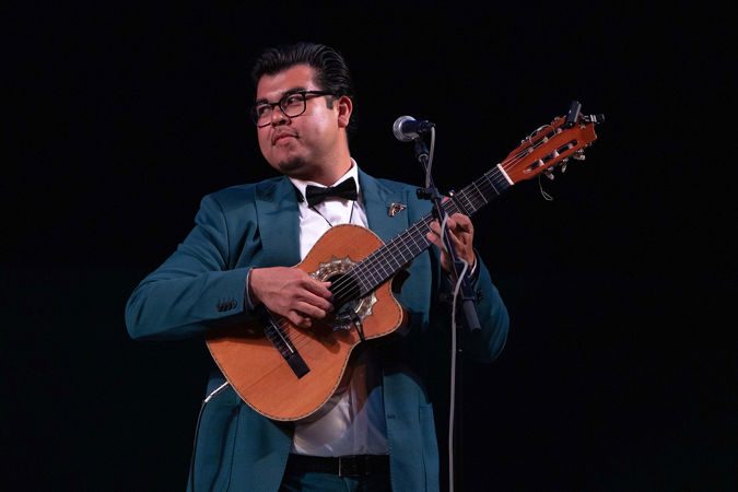Jesus Martinez of the trio Tres Souls plays the guitar while looking for a cue from his fellow bandmates