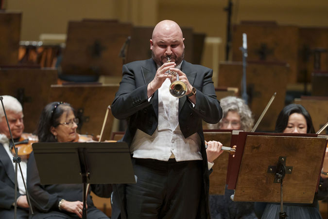 Closeup action shot of CSO principal trumpet Esteban Batallán performing on stage