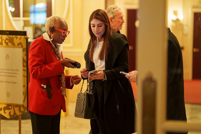 an usher scans an audience member's ticket