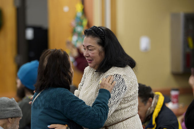 Two community members from the Southwest Regional Senior Center hugging during the 2025 Civic Bach Marathon concert