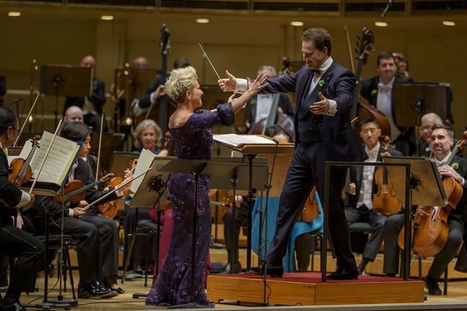 CSO Artist-in-Residence and mezzo-soprano Joyce DiDonato and conductor Nikolaj Szeps-Znaider walking towards each other for a hug on stage