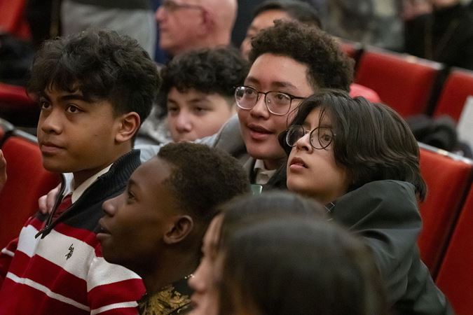 a group of young audience members looks on