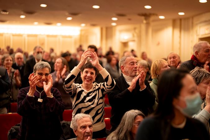 Smiling patrons applauding on the main floor