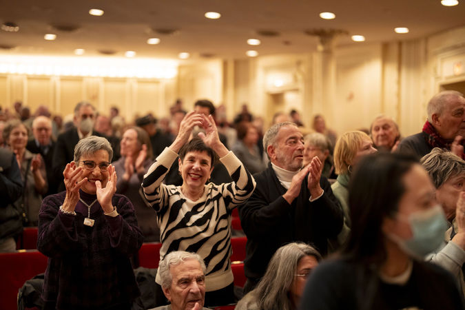 Smiling patrons applauding on the main floor
