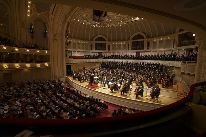 a view from the right side of the box level as Riccardo Muti raises his arms with vigor to signal the CSO and Chorus