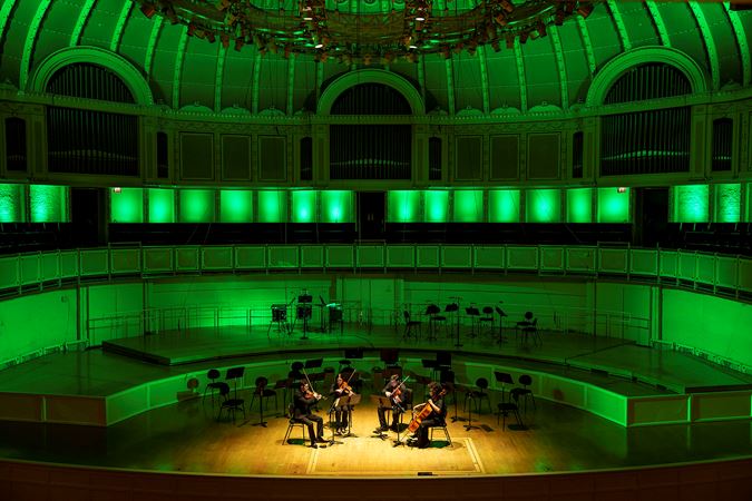 a string quartet performs Jimmy López's La Caresse du Couteau against a green-lit stage