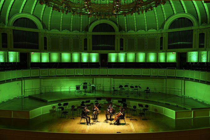 a string quartet performs Jimmy López's La Caresse du Couteau against a green-lit stage