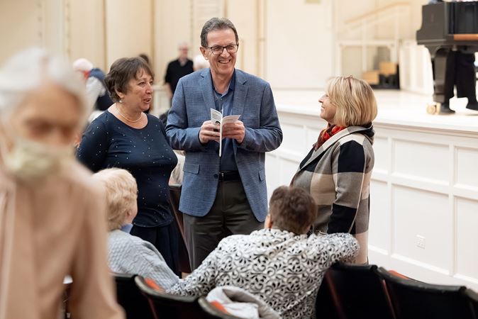 patrons in the front row mingle and share a laugh preconcert