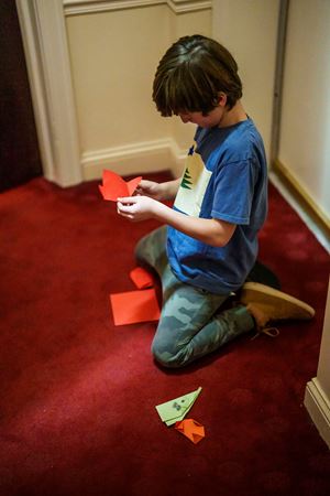 a young audience member folds origami