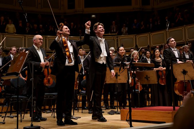 guest violist Antoine Tamestit and CSO Zell Music Director Designate Klaus Mäkelä raise their hands in a bow after performing Berlioz's Harold in Italy