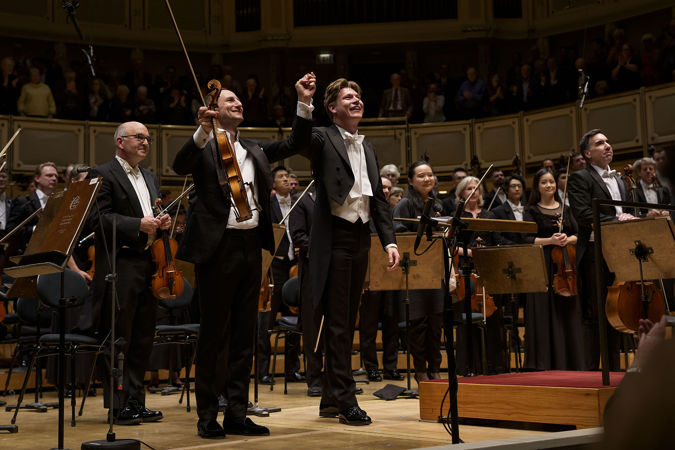 guest violist Antoine Tamestit and CSO Zell Music Director Designate Klaus Mäkelä raise their hands in a bow after performing Berlioz's Harold in Italy