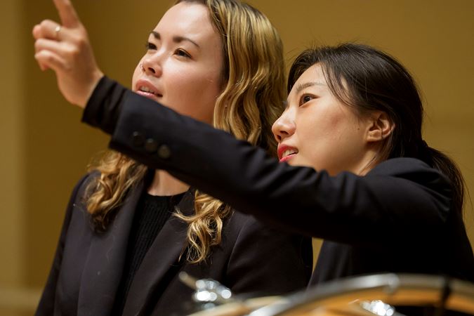 Closeup shot of two Civic percussionists looking out into the audience from the stage