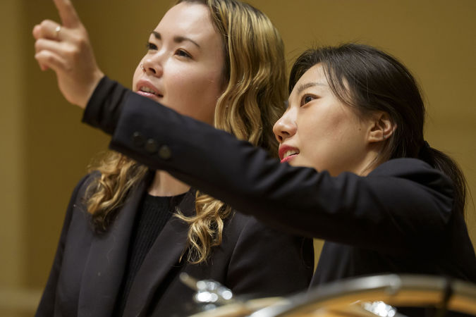 Closeup shot of two Civic percussionists looking out into the audience from the stage
