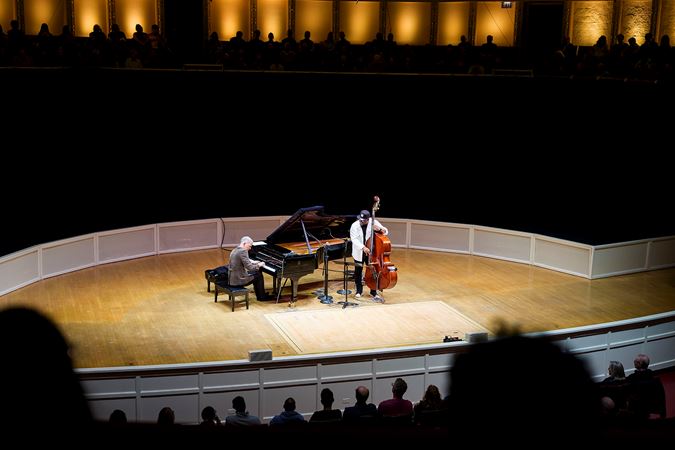 a wide shot from the perspective of audience members watching Christian and Brad perform from the box level
