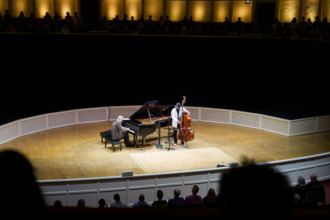 a wide shot from the perspective of audience members watching Christian and Brad perform from the box level