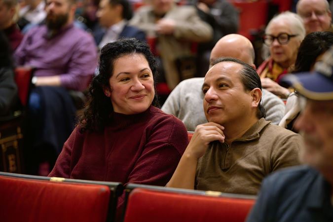 a couple eagerly awaits the performance in their seats