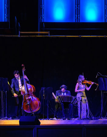 a small ensemble of musicians, including bass, bandoneon and violin, performs a piece by Astor Piazzolla