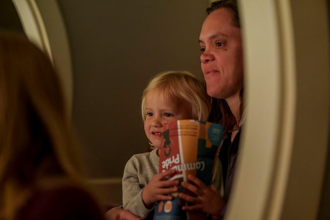 A young audience member smiling and holding a CSO for Kids program book