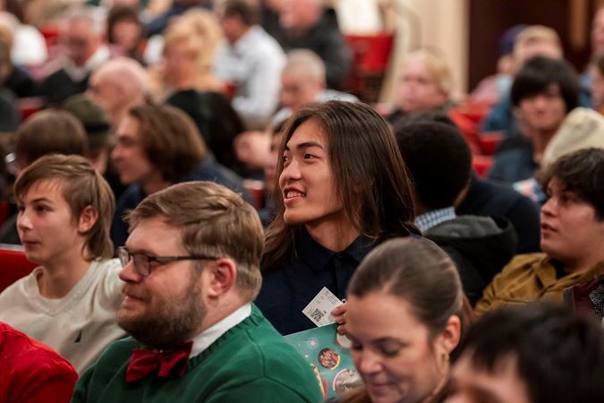 a young audience member smiles amid the crowd