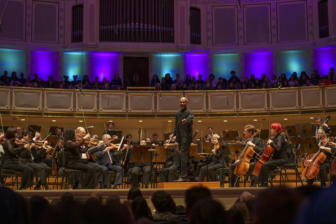 Wide shot of members of the CSO and conductor Thomas Wilkins performing on stage