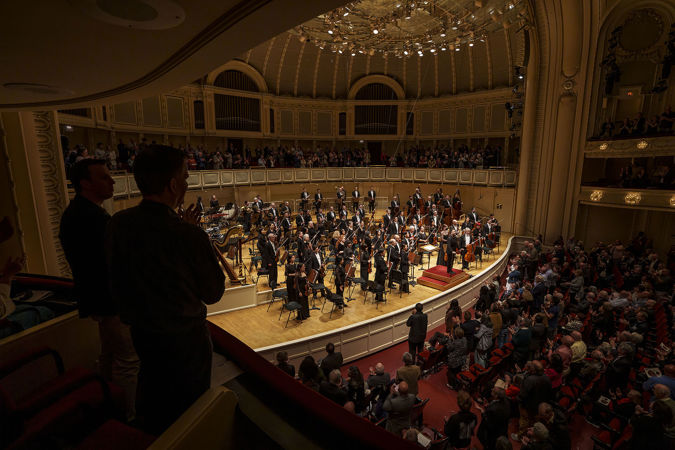 the audience gives the CSO and guest conductor James Gaffigan a standing ovation, as seen from the left side of the box level