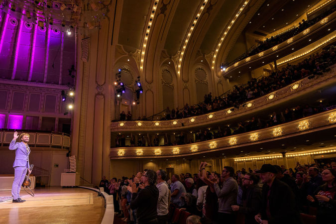 Chris Thile gives the audience a wave as they rise to their feet to give him an ovation